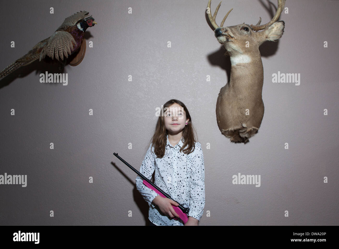 Home portrait of girl holding pink shotgun Stock Photo