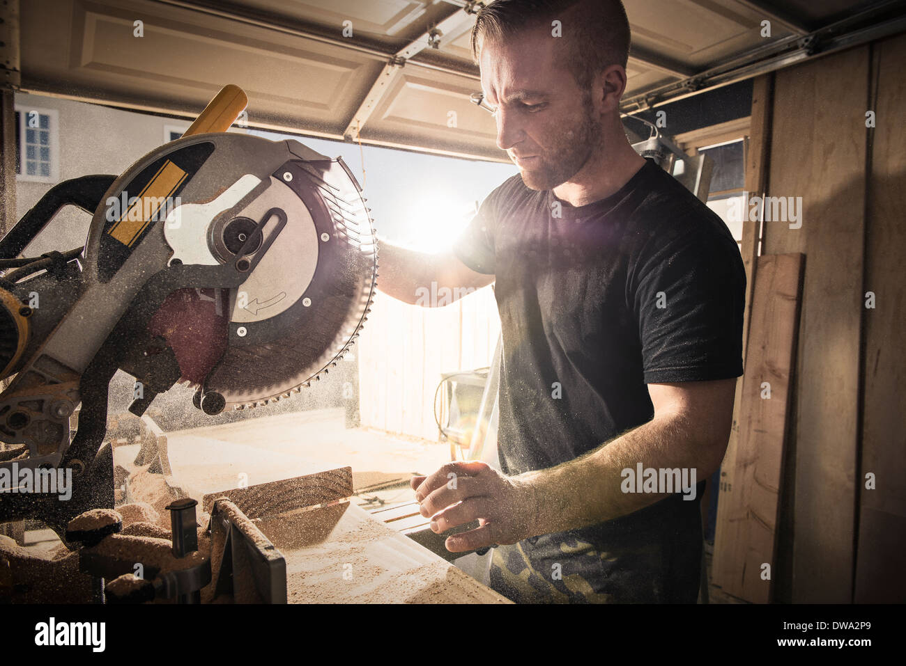 Male carpenter working with a rotary saw in workshop Stock Photo