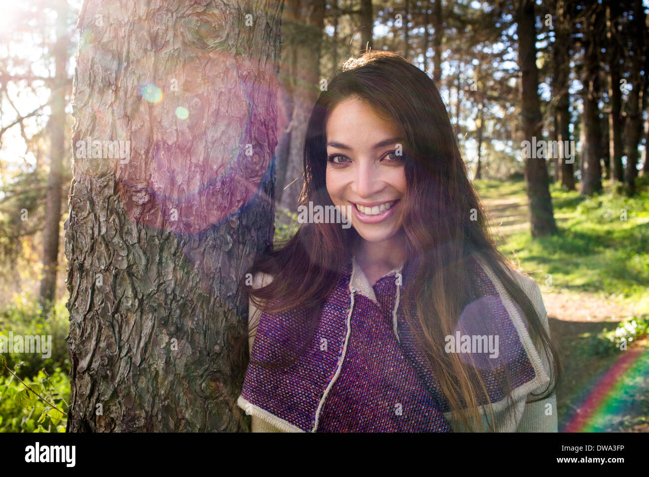 Portrait of young woman in sunlit forest Stock Photo