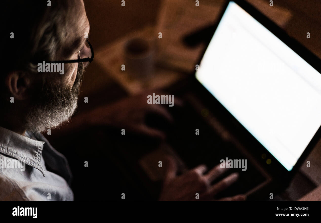 Mature man using laptop with blank screen Stock Photo