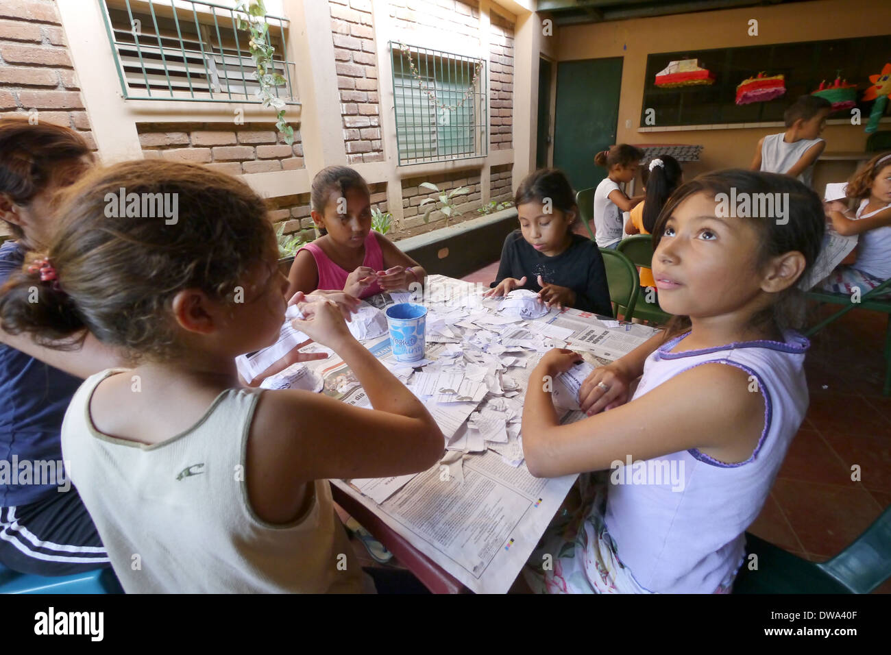 Children making baskets from scrap paper Stock Photo