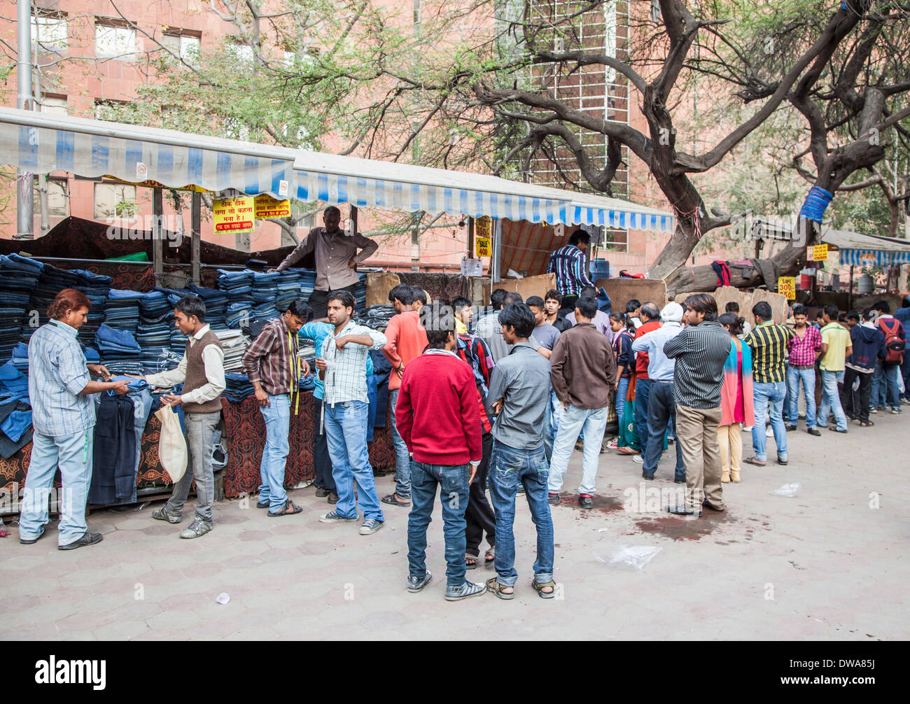 Crowded local market in New Delhi, India: roadside stall on street selling blue denim jeans piled high Stock Photo
