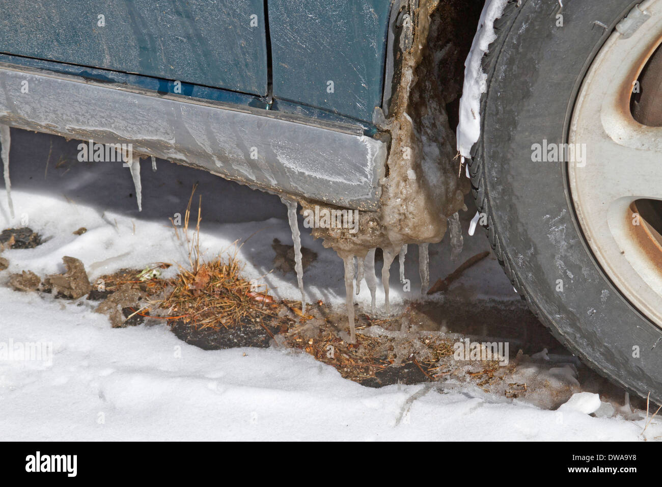 A car with icicles hanging from it begins a winter thaw Stock Photo