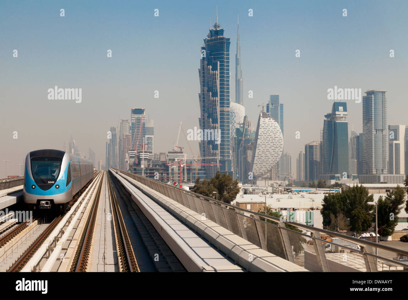 A train on the Dubai Metro with skyscrapers on the skyline including the Burj Khalifa; Dubai, UAE, Middle East Stock Photo
