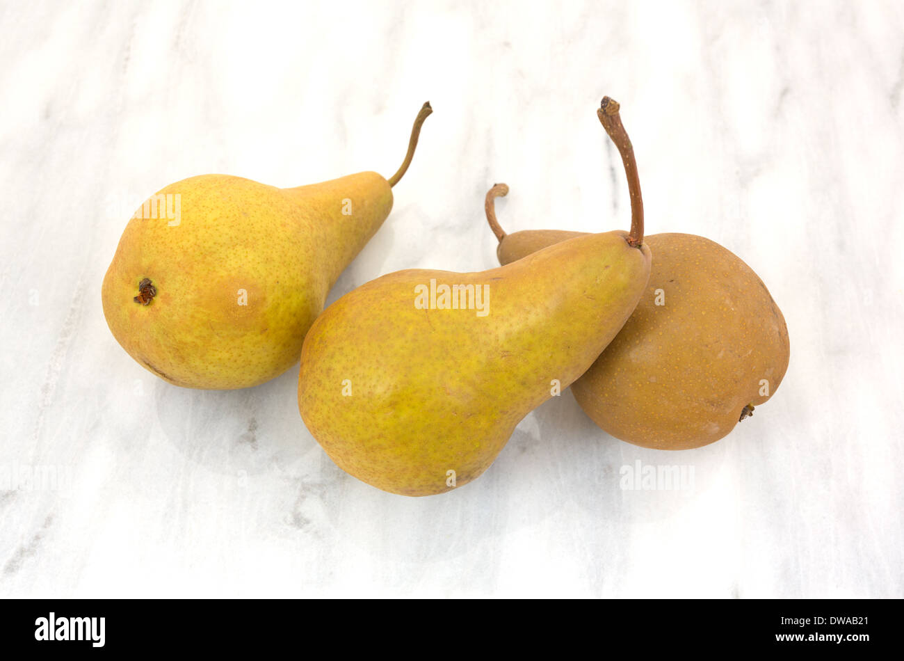 Three ripe bosc pears on a marble cutting Stock Photo Alamy