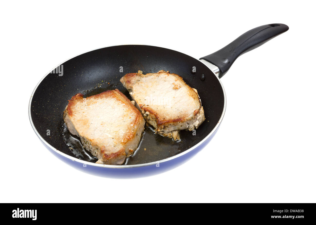 Two pork loin steaks frying in a skillet on a white background. Stock Photo