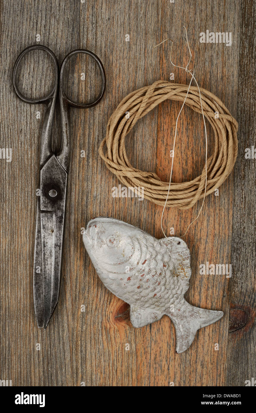 old scissors, glasses, fish and hank of packthread over wooden background Stock Photo