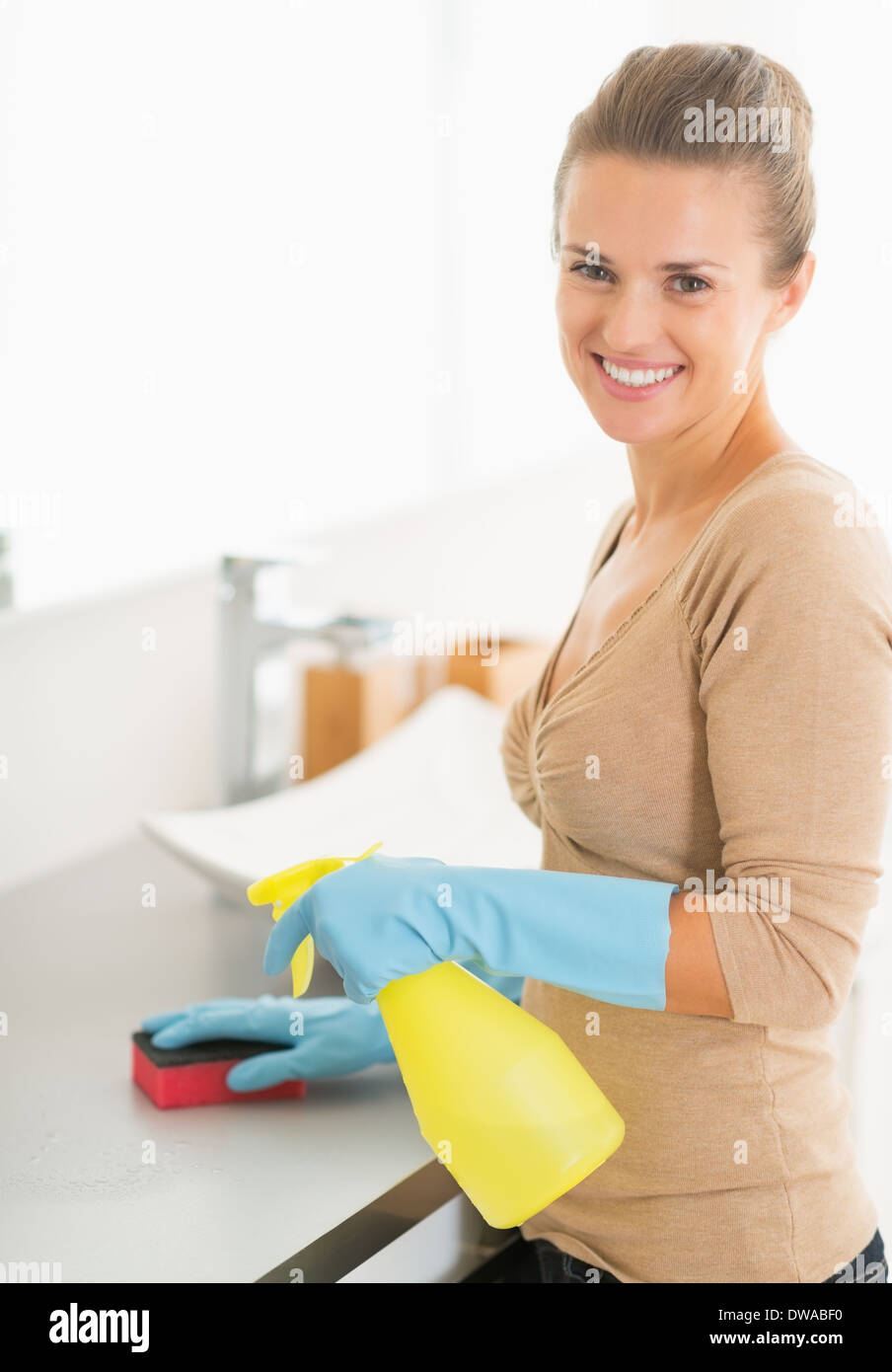 Portrait of smiling housewife cleaning desk in bathroom Stock Photo - Alamy