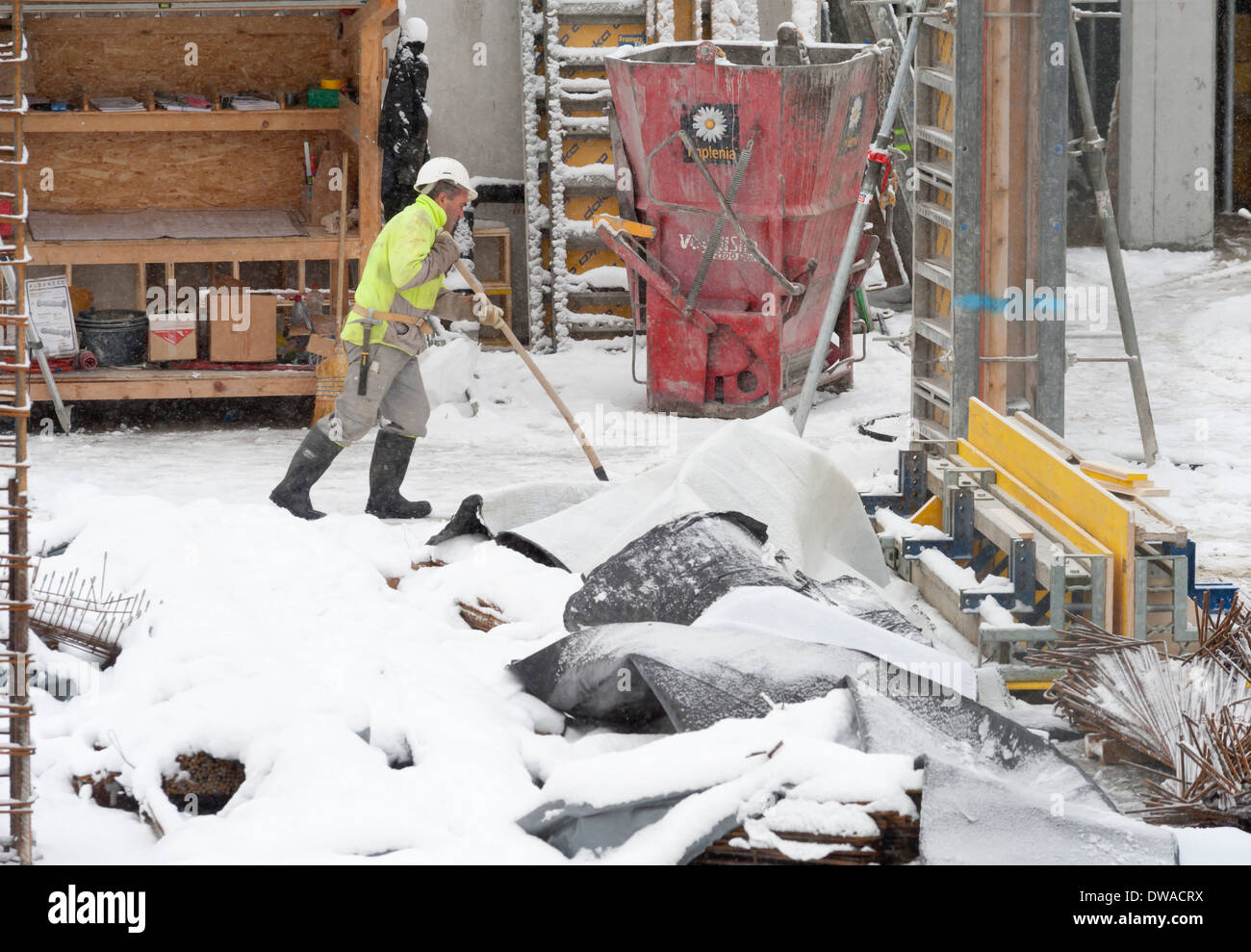 Construction workers and building activity on a snowed winter
