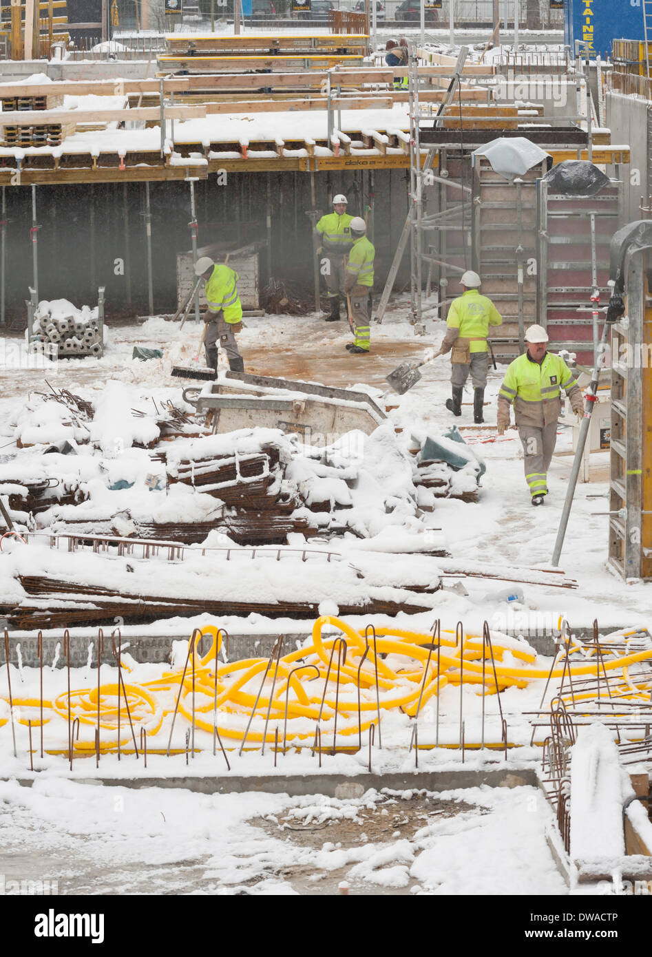 Construction workers and building activity on a snowed winter