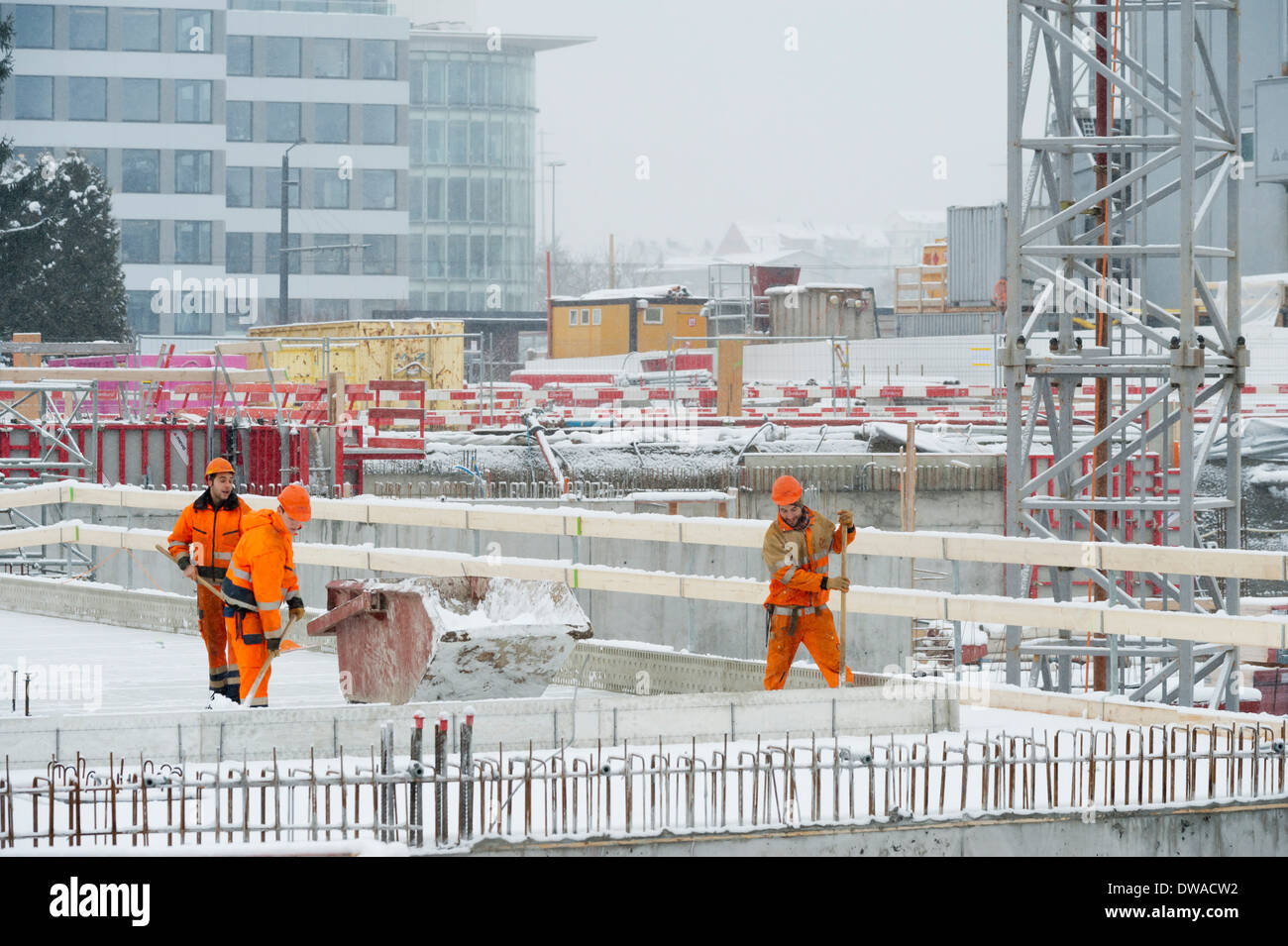 Construction workers and building activity on a snowed winter