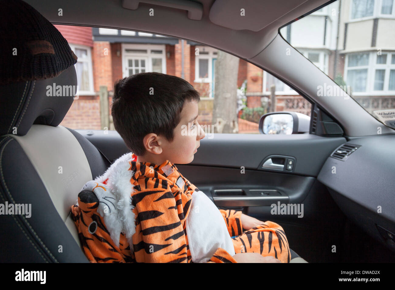 Child sitting in a car ,dressed in tiger costume Stock Photo