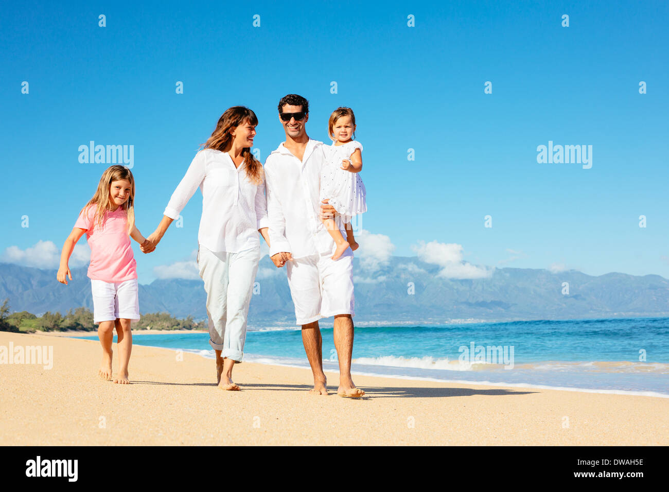 Happy family walking on the beach Stock Photo