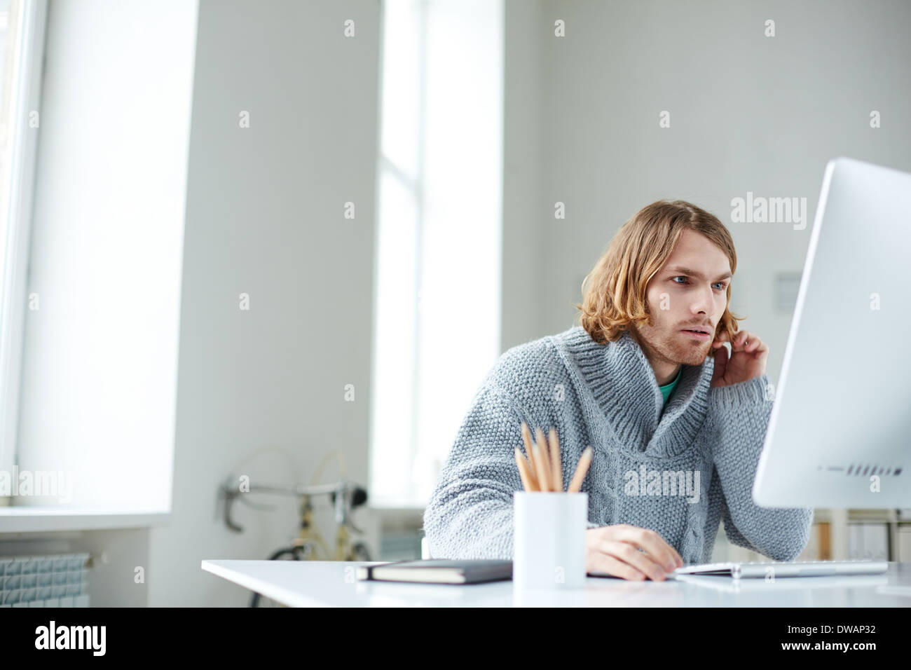Portrait of serious guy working with computer in office Stock Photo