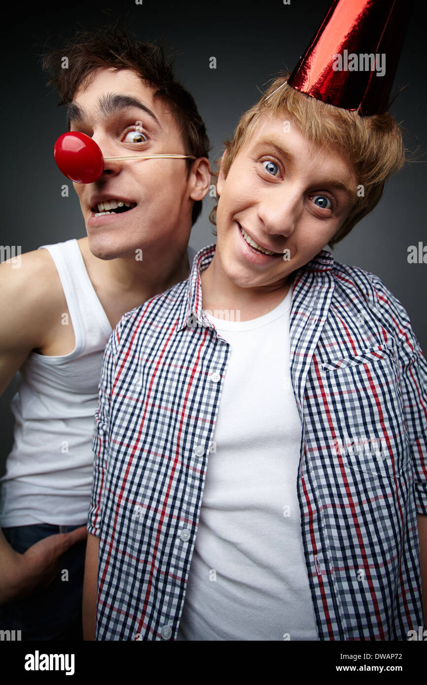 Two funny guys looking at camera and smiling crazily, fool’s day series Stock Photo