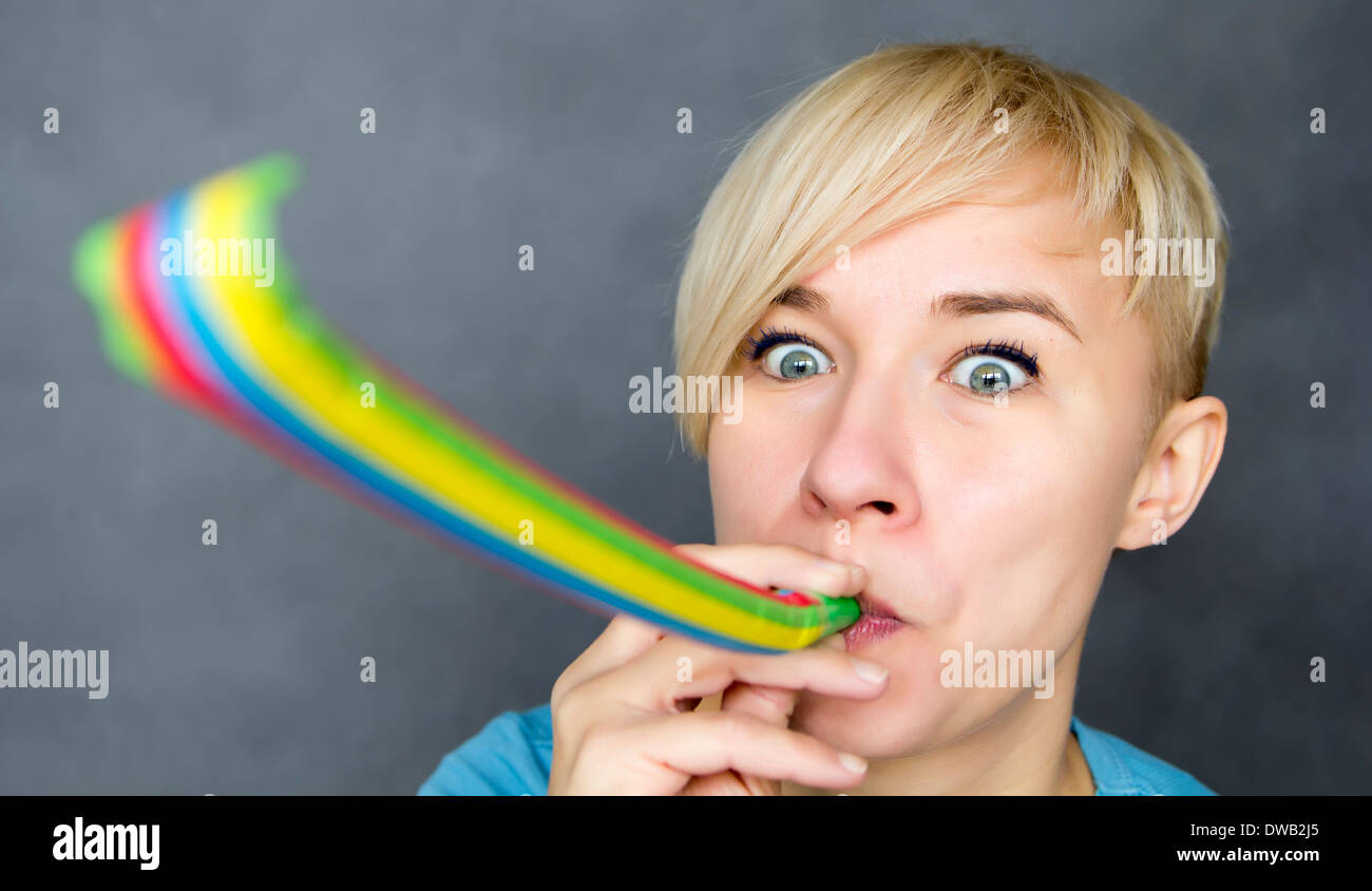 portrait of woman blowing a party blower Stock Photo - Alamy