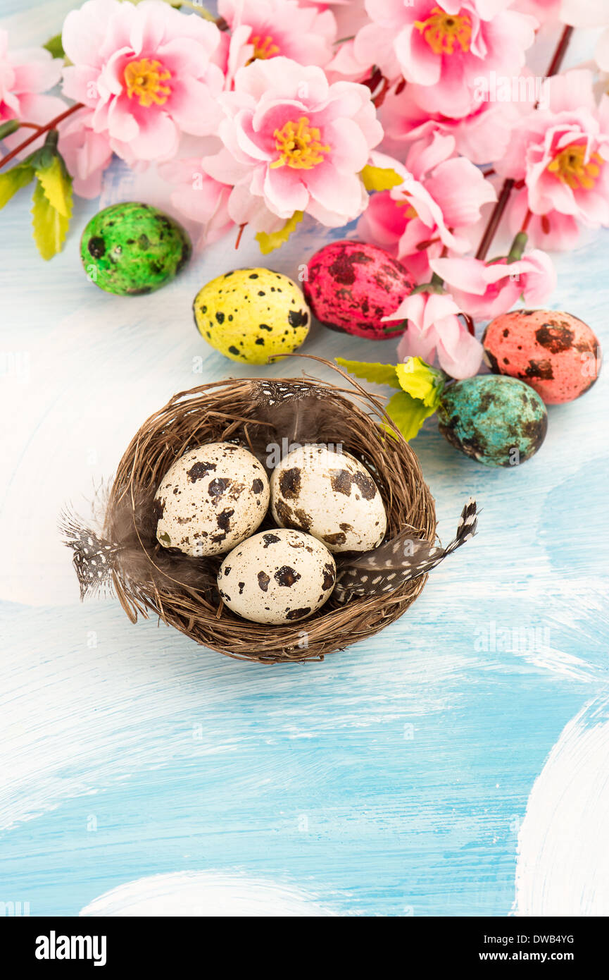 Easter decoration with flowers and eggs in nest. Handmade colored quail ...