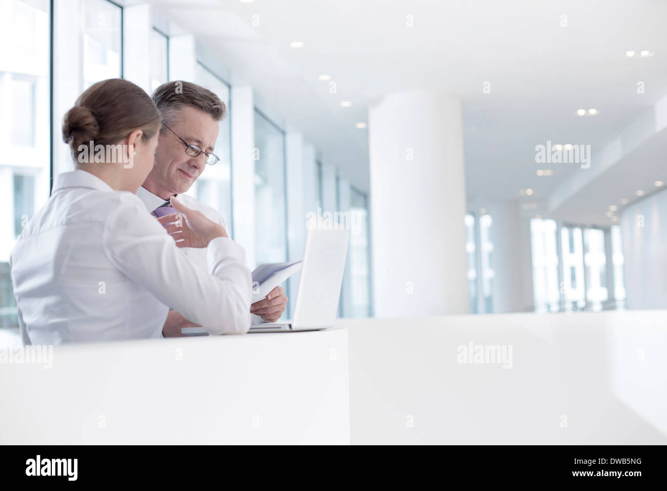 Business people working at railing in office Stock Photo