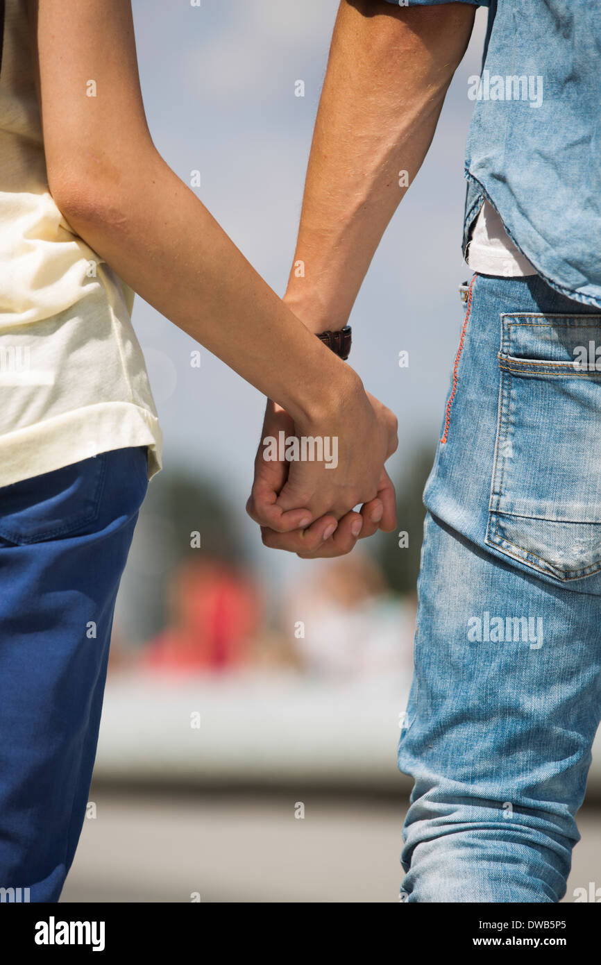 Mid section of couple holding hands outdoors Stock Photo