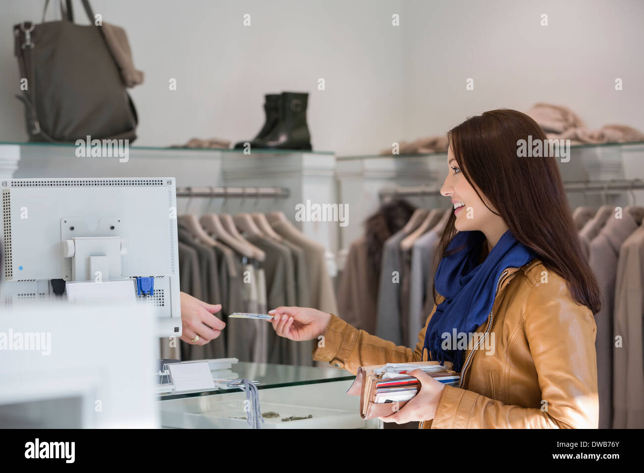 Young woman giving credit card to cashier Stock Photo