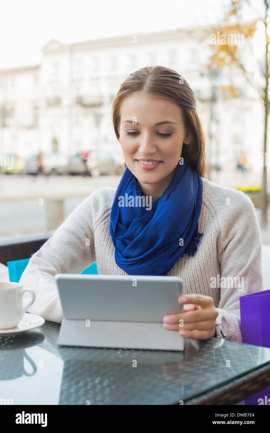 Young woman using tablet PC at sidewalk cafe Stock Photo