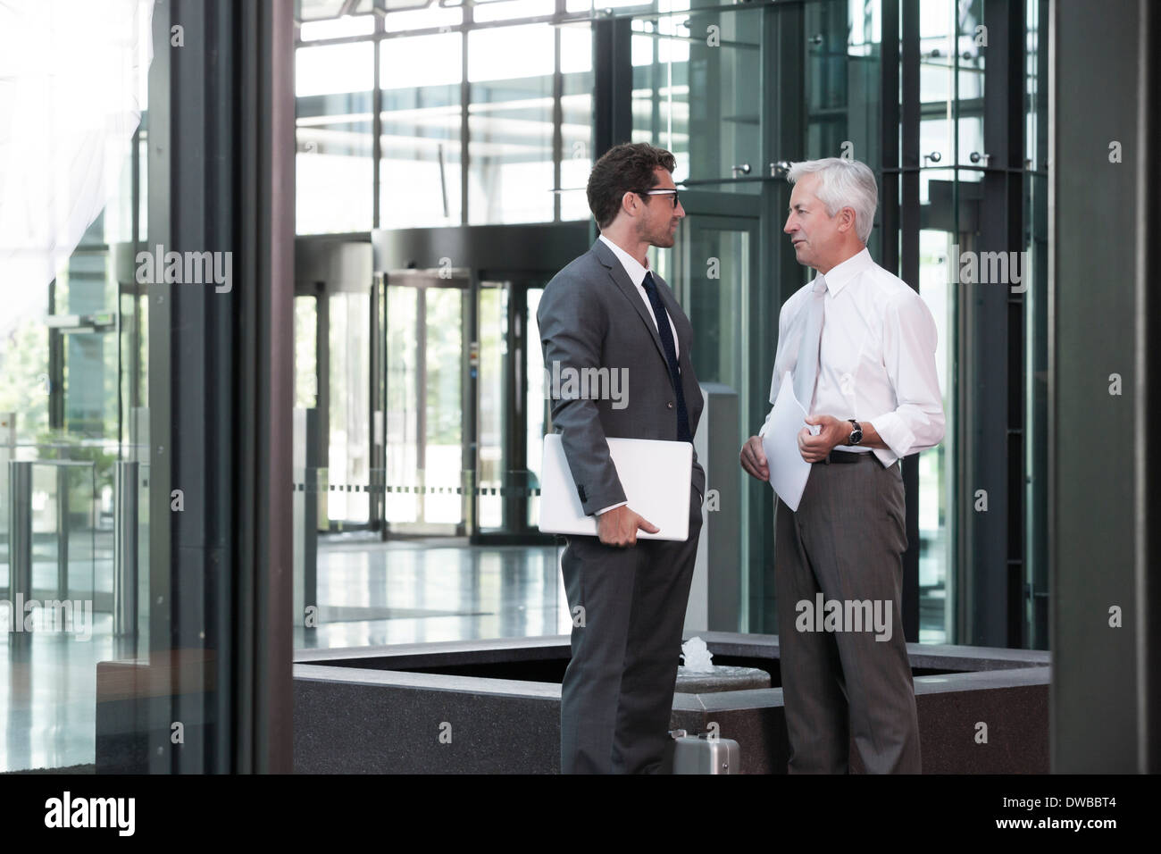 Two businessmen talking in lobby Stock Photo - Alamy