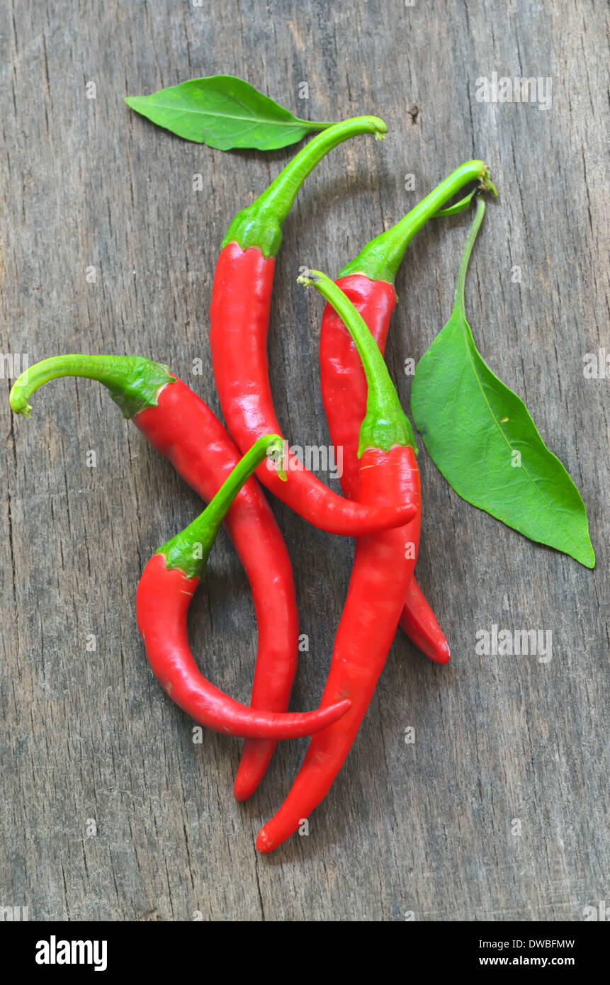 Red chili peppers over wooden background Stock Photo - Alamy