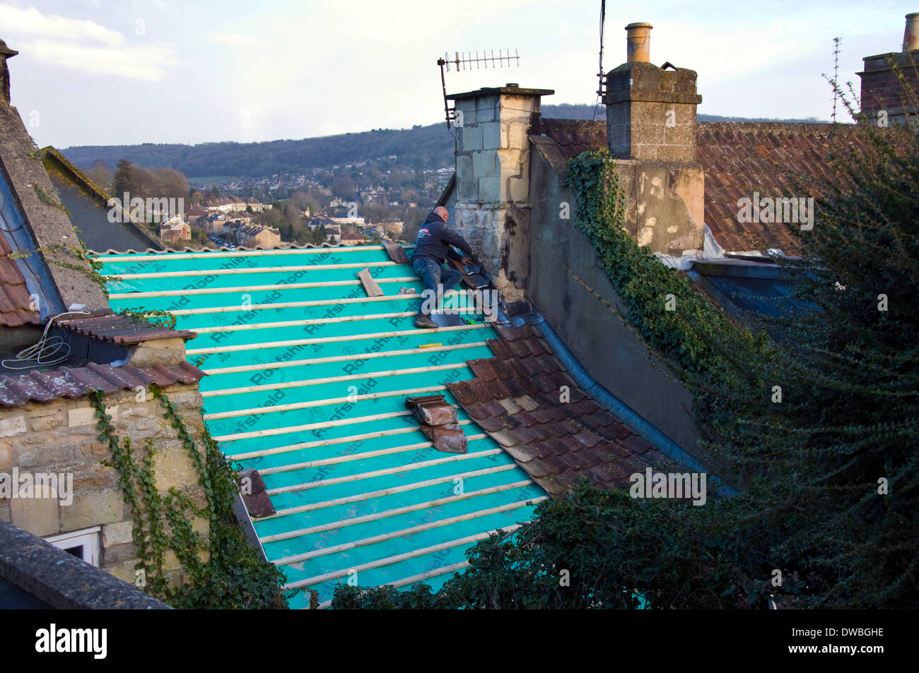 A man roofing a grade two listed terraced cottage in Batheaston near Bath Somerset England UK Stock Photo