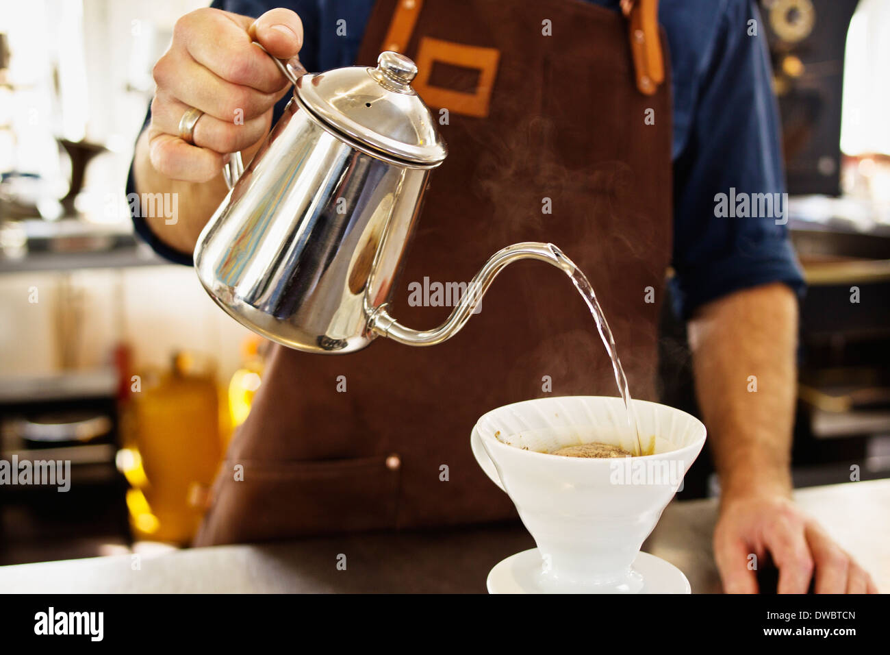 Close up of barista pouring boiling water into coffee filter Stock