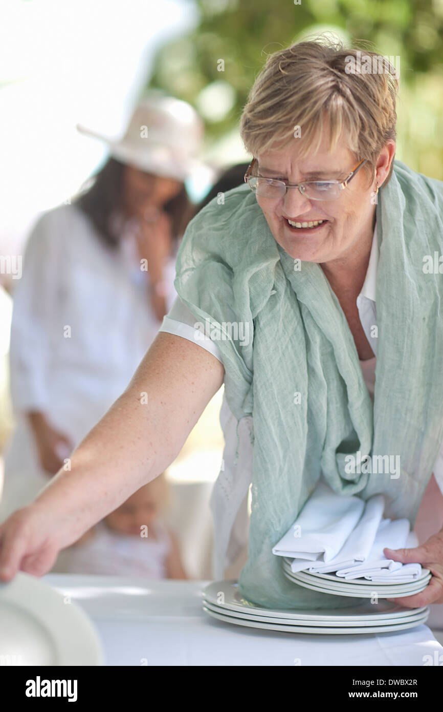 Senior woman setting table Stock Photo