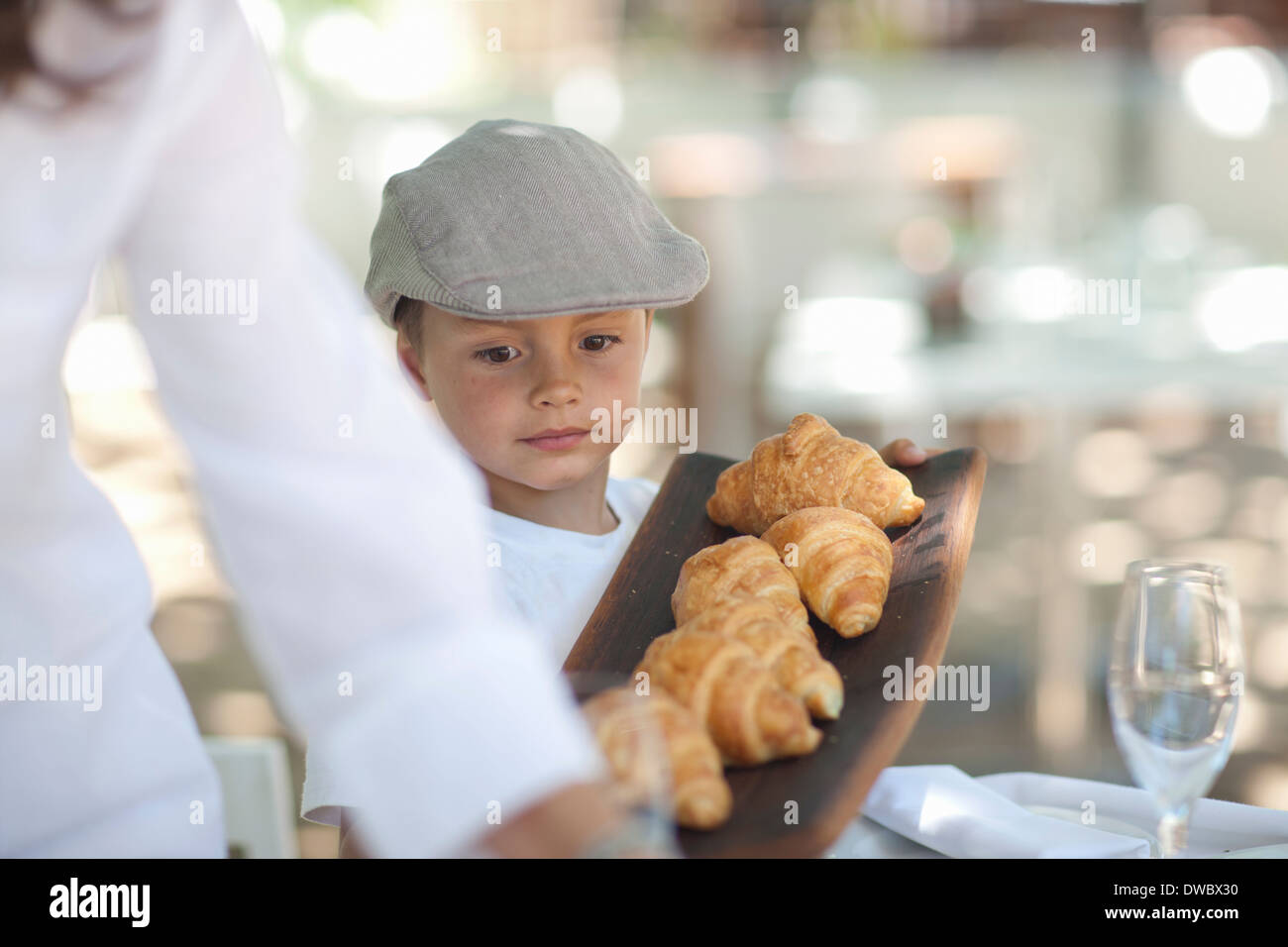 Boy serving platter of croissant Stock Photo Alamy