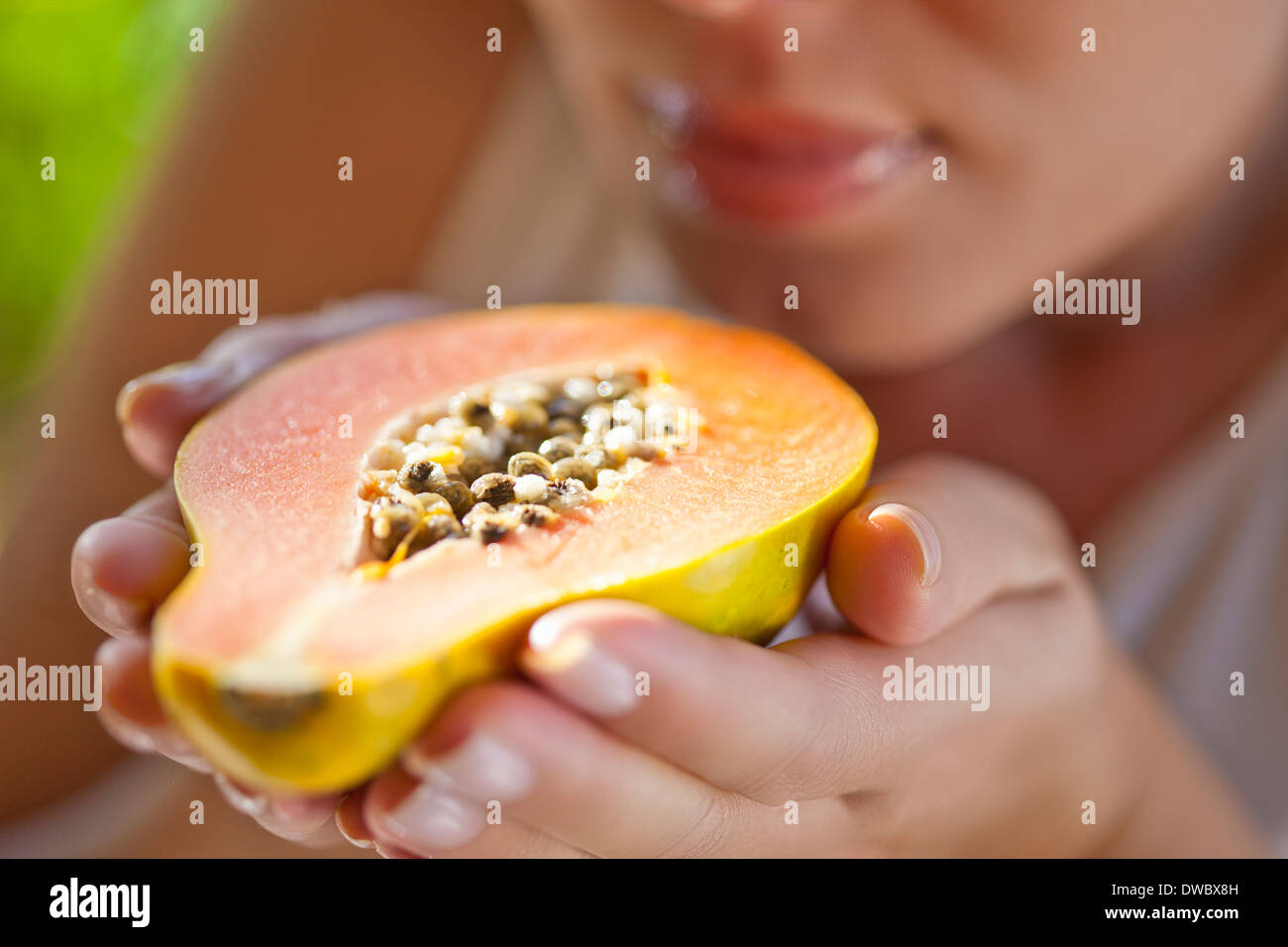 Woman holding up halved papaya Stock Photo