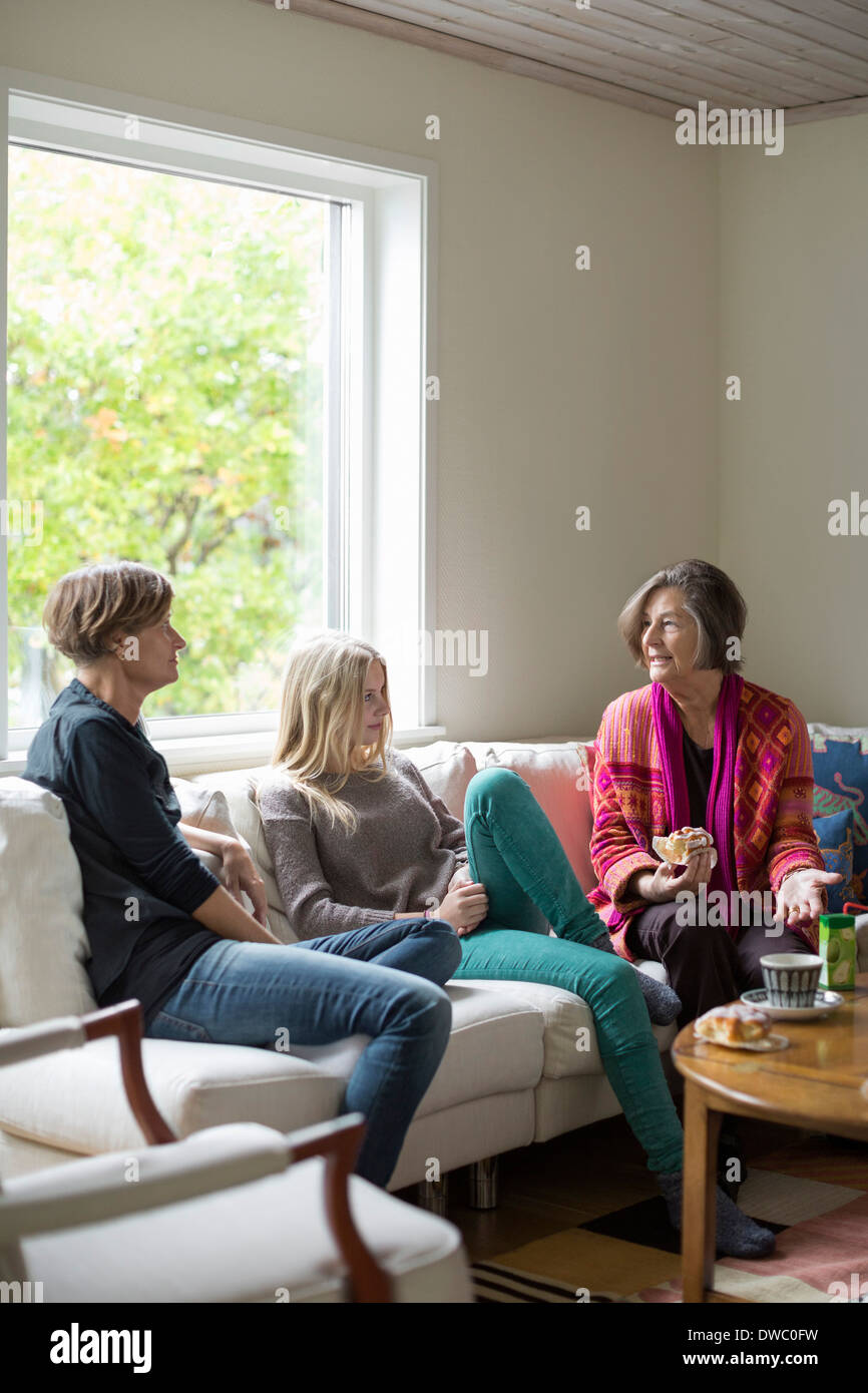 Three generation females spending leisure time in living room Stock Photo