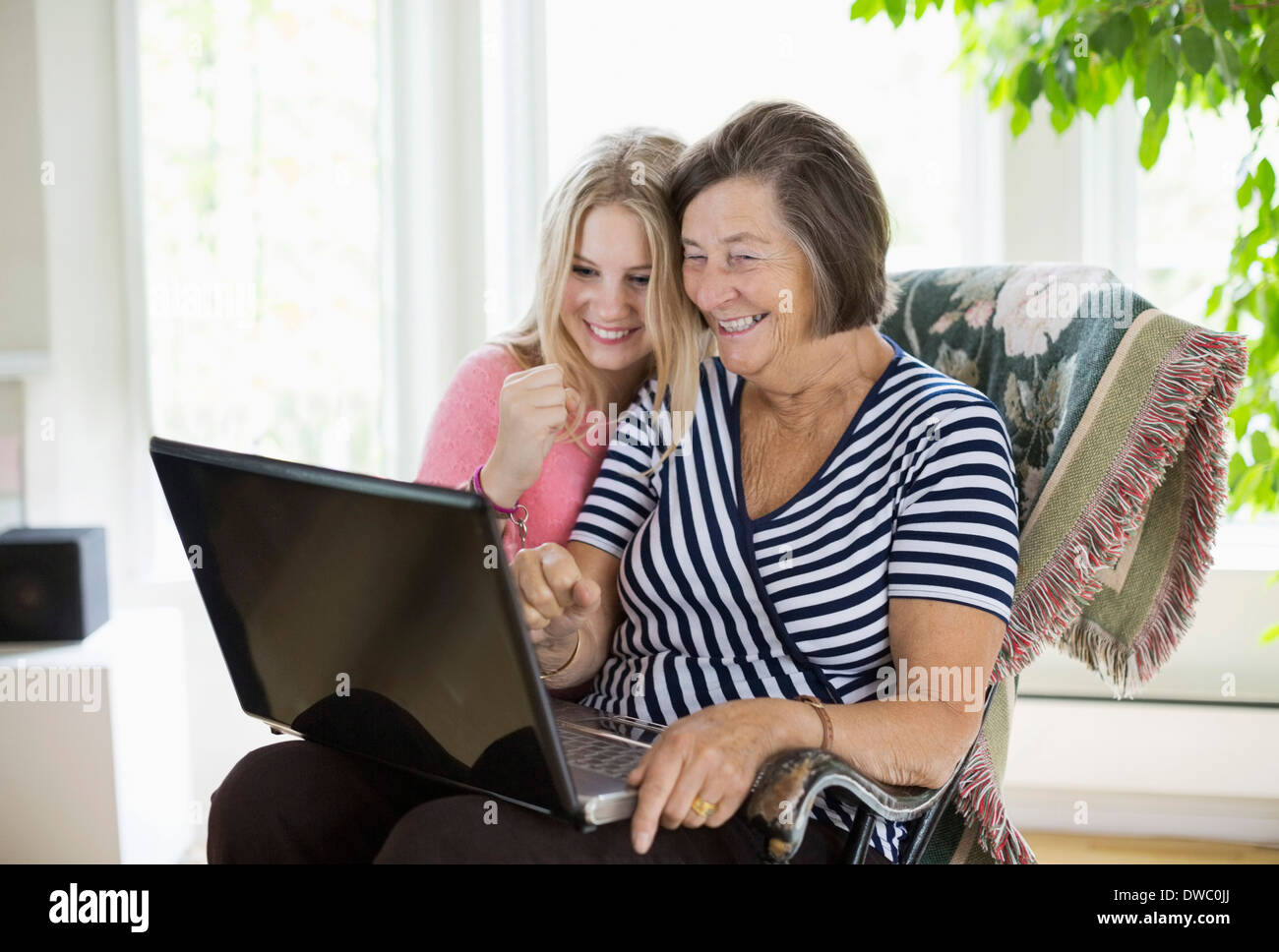 Happy grandmother and granddaughter using laptop at home Stock Photo ...
