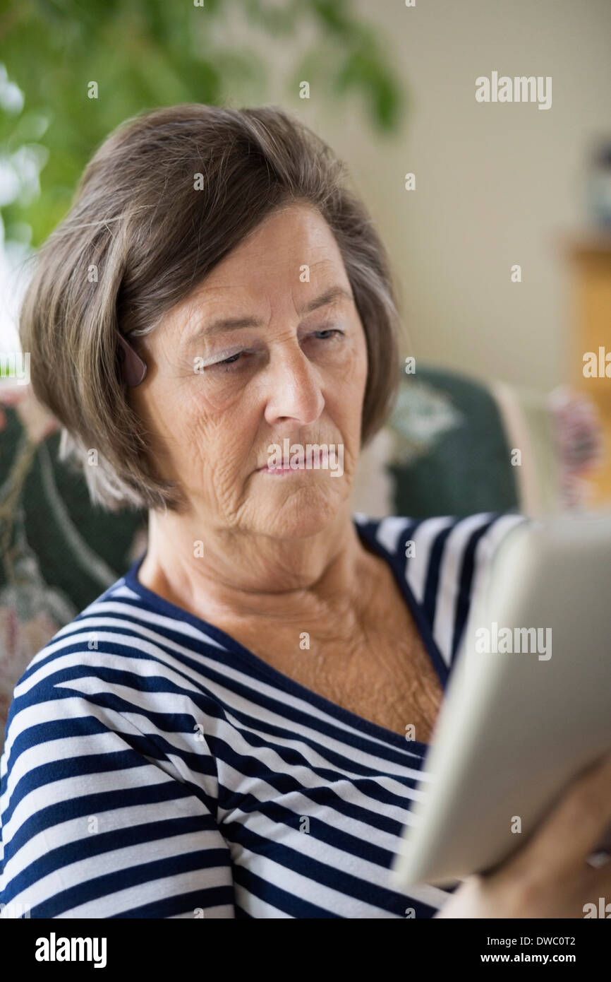 Senior woman using digital tablet at home Stock Photo