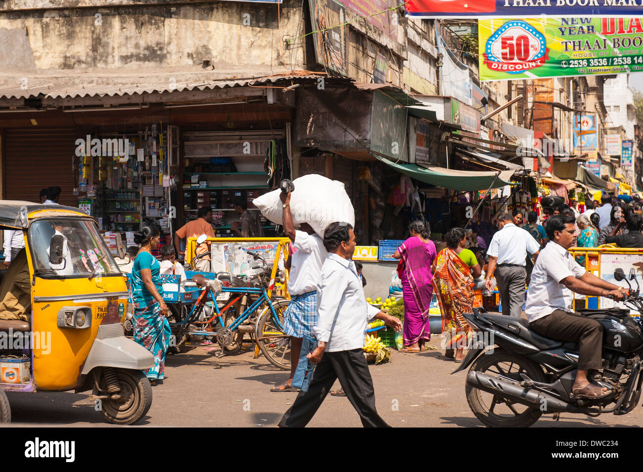 India capital Tamil Nadu Chennai  Madras South Southern busy shopping shops street scene motorbike tuk tuk auto rick shoppers sack head busy crowd sari Stock Photo