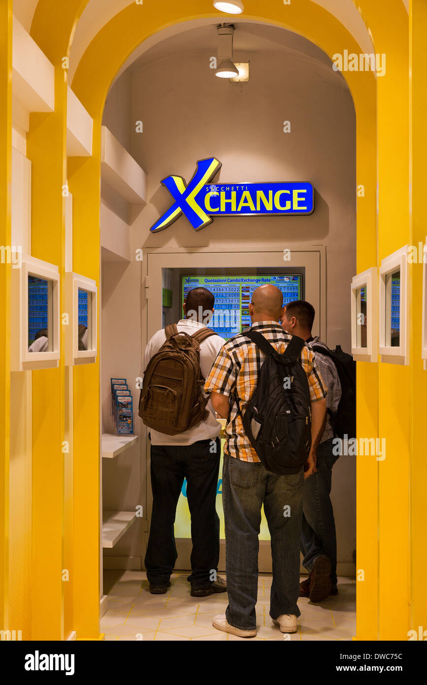 Young travelers exchange currency at an automated exchange booth, Rome, Italy. Stock Photo