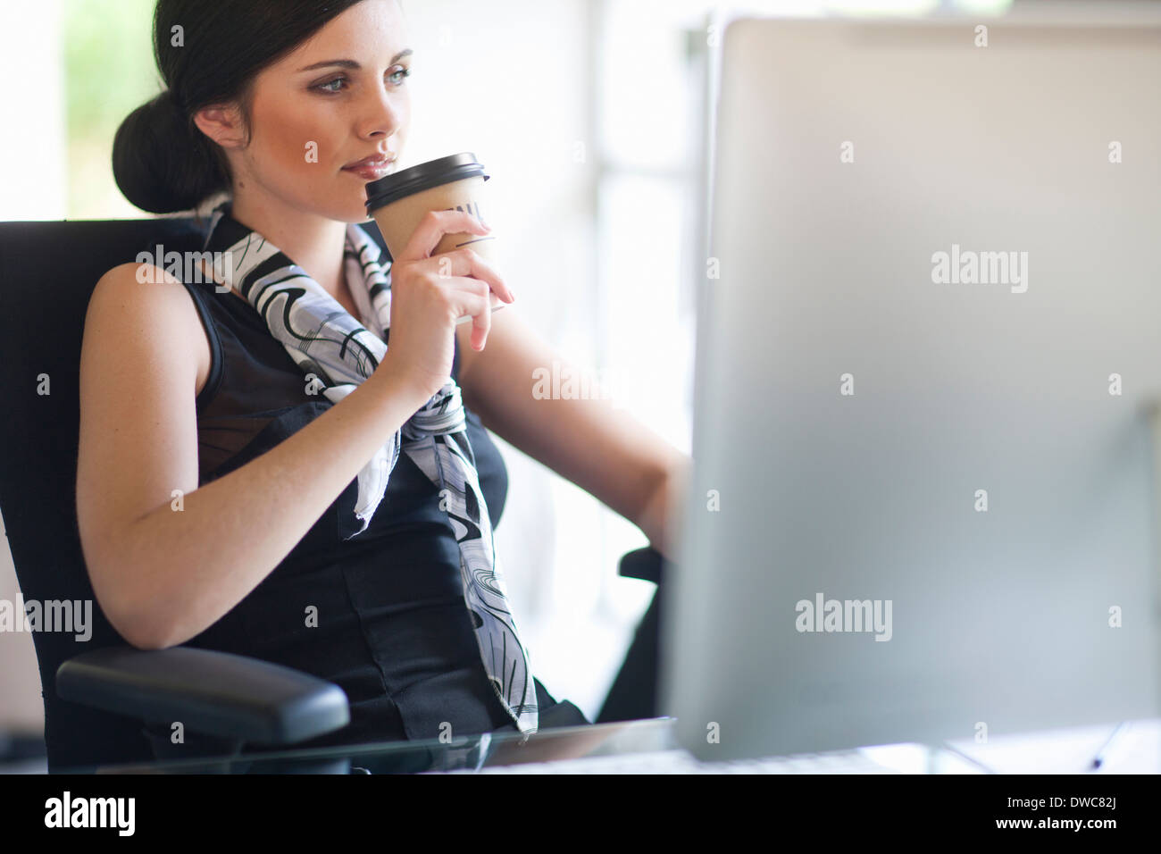 Young businesswoman taking a coffee break at desk Stock Photo - Alamy
