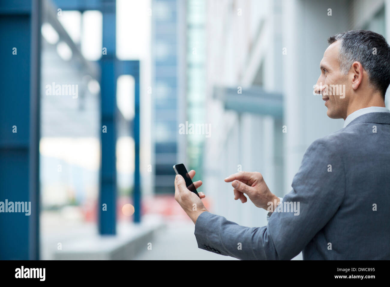 Businessman using touchscreen on smartphone Stock Photo