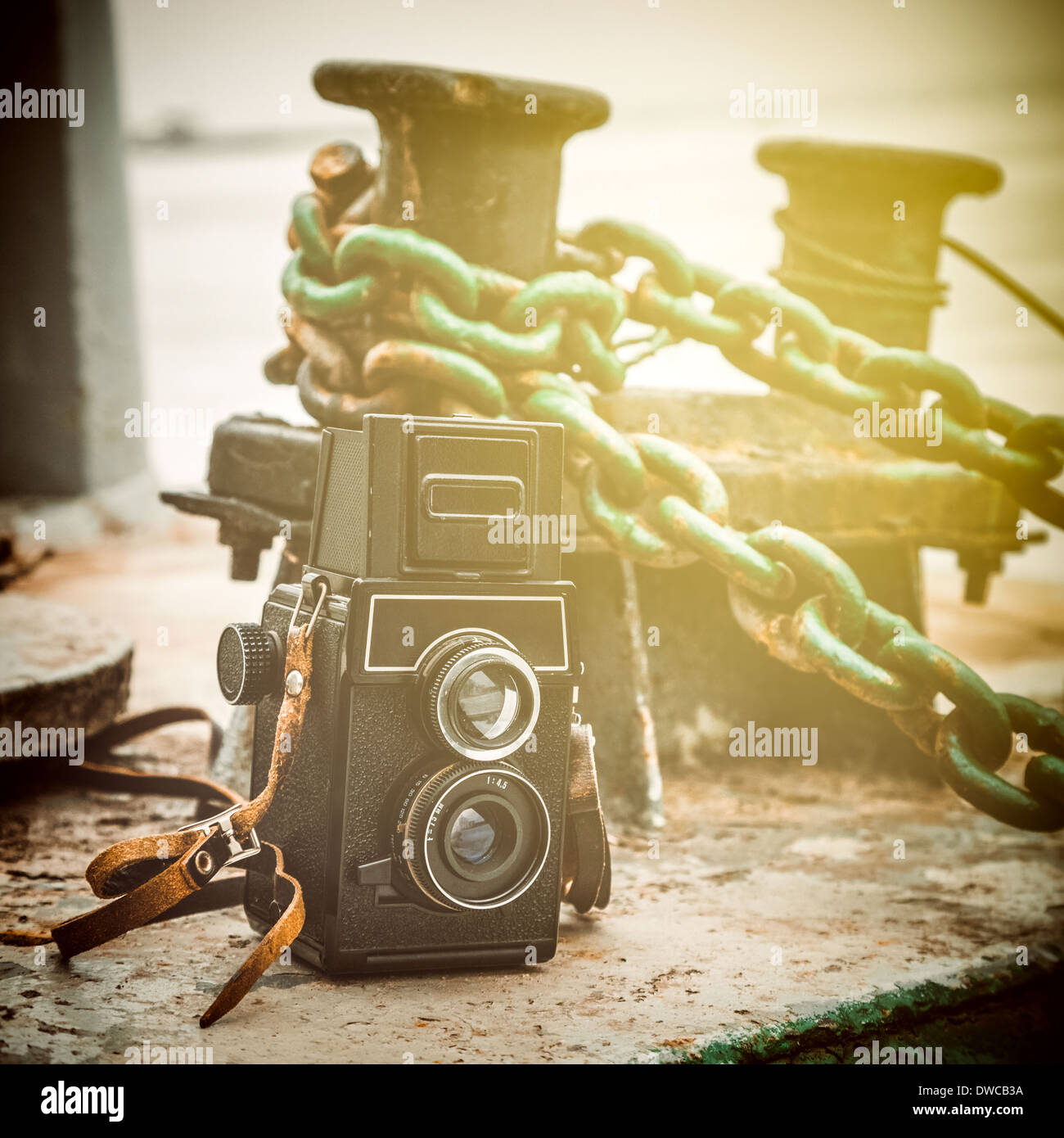 vintage camera near a mooring bollard on pier, retro stylized Stock Photo