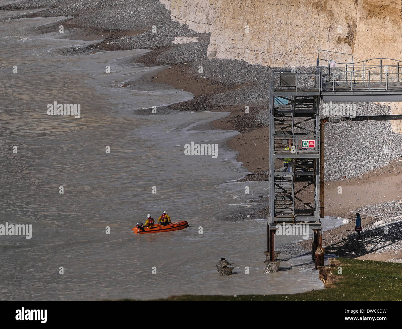 BirlingGap,East Sussex,UK..5 March 2014..A young woman  is rescued from BirlingGap beach, having walked from Cuckmere Haven to find the beach access steps cut off at the bottom due to storm damage. Trapped by the rising tide RNLI Newhaven took her off the beach in a dingy to the lifeboat waiting off shore.David Burr/Alamy Live News Stock Photo