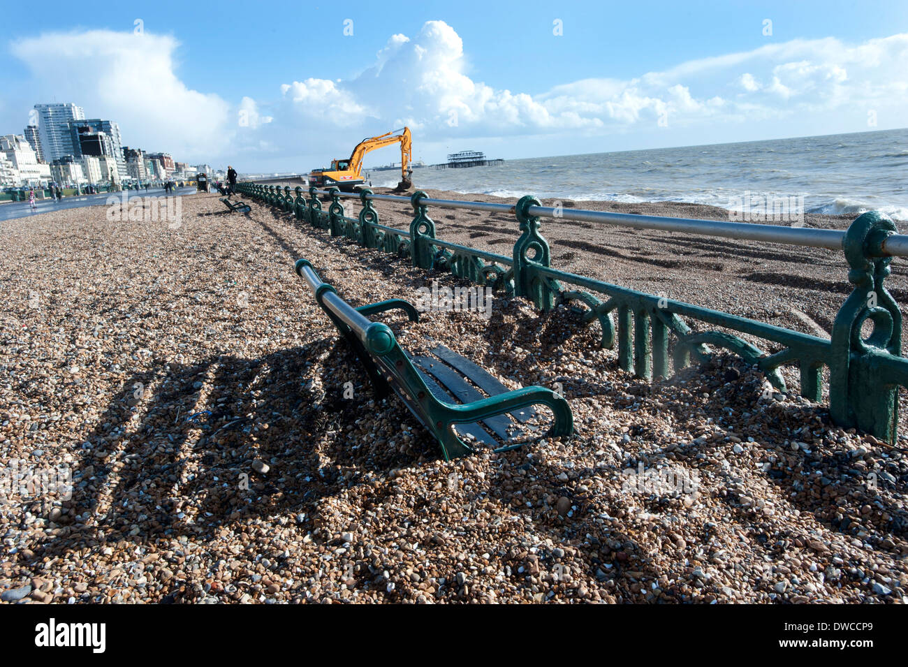 Brighton Beach after storms that drove thousands of tons of shingle and pebbles from the beach up onto the promenade, swamping the benches on the prom. Stock Photo