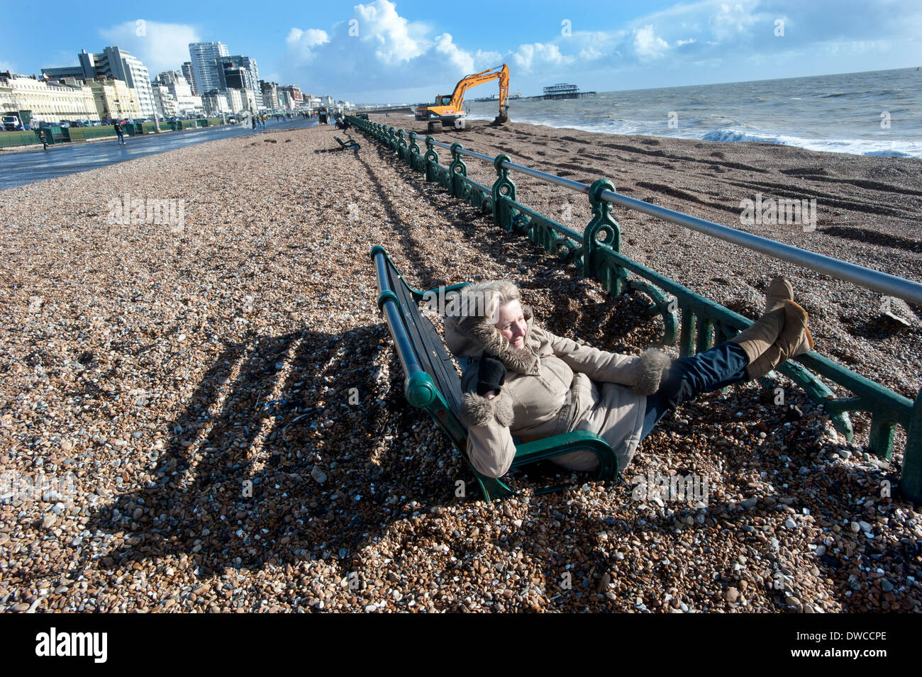 Brighton Beach after storms that drove thousands of tons of shingle and pebbles from the beach up onto the promenade, swamping the benches on the prom. Stock Photo
