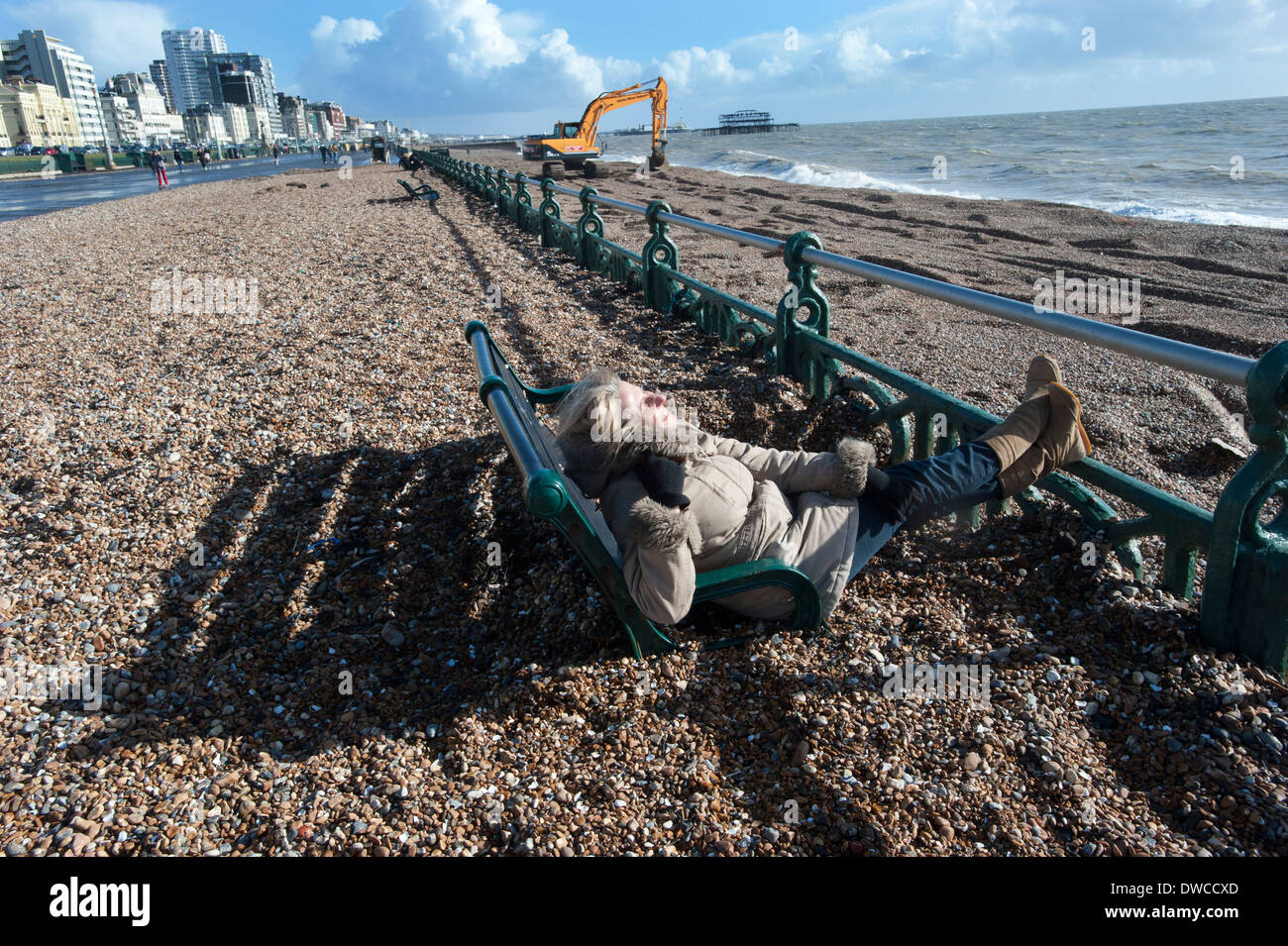 Brighton Beach after storms that drove thousands of tons of shingle and pebbles from the beach up onto the promenade, swamping the benches on the prom. Stock Photo
