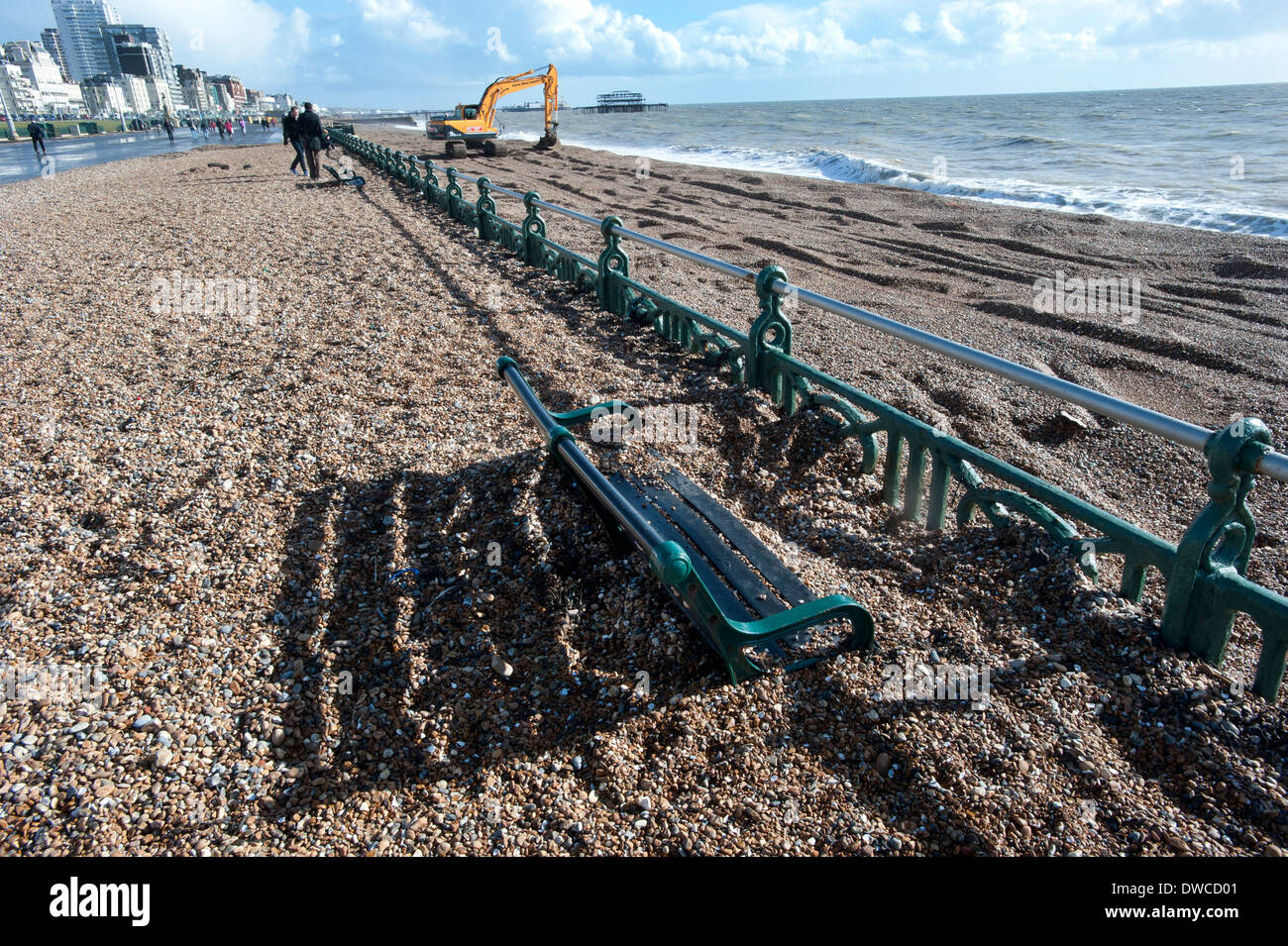 Brighton Beach after storms that drove thousands of tons of shingle and pebbles from the beach up onto the promenade, swamping the benches on the prom. Stock Photo