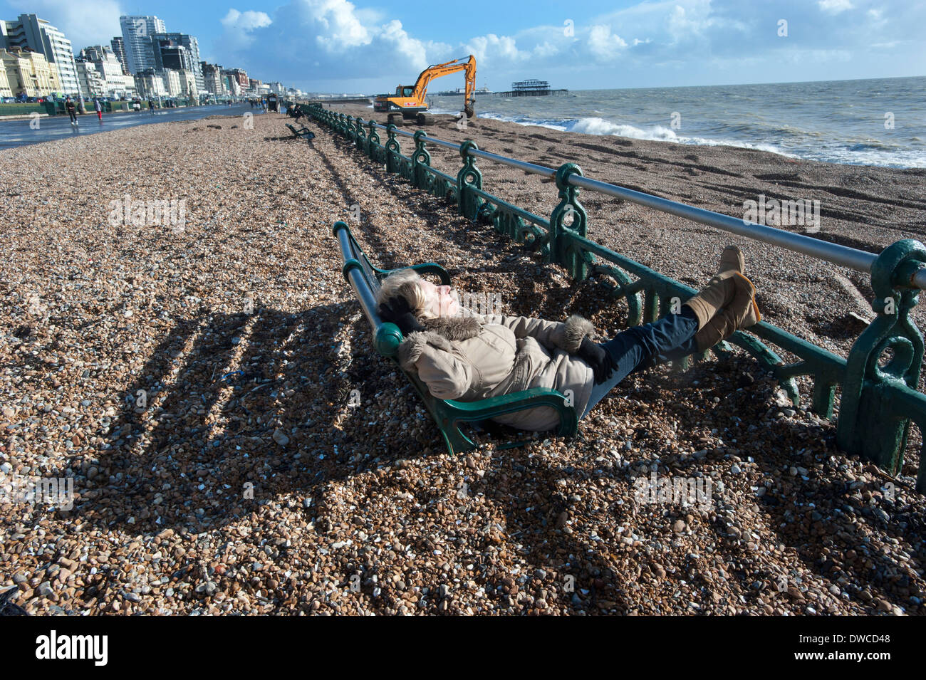 Brighton Beach after storms that drove thousands of tons of shingle and pebbles from the beach up onto the promenade, swamping the benches on the prom. Stock Photo