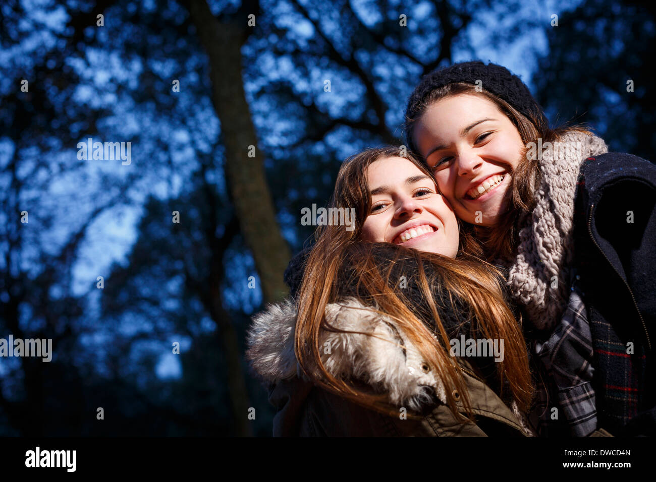 Sisters hugging in forest at dusk Stock Photo - Alamy