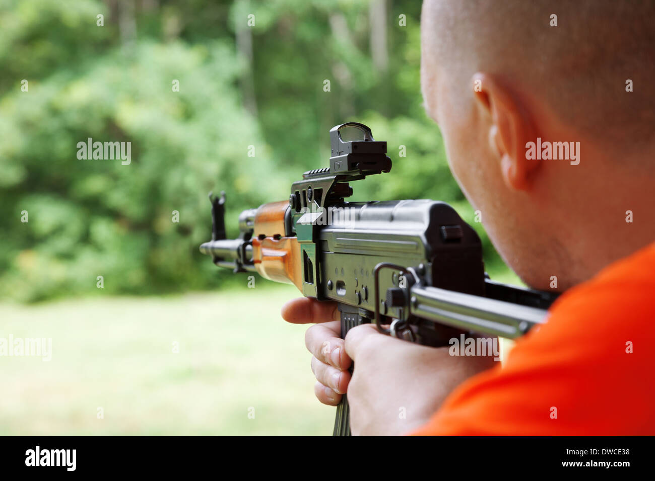 Man shooting an automatic rifle for strikeball. Focus on the rifle sights. Stock Photo