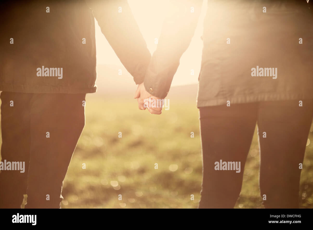 Mid section of couple, holding hands Stock Photo