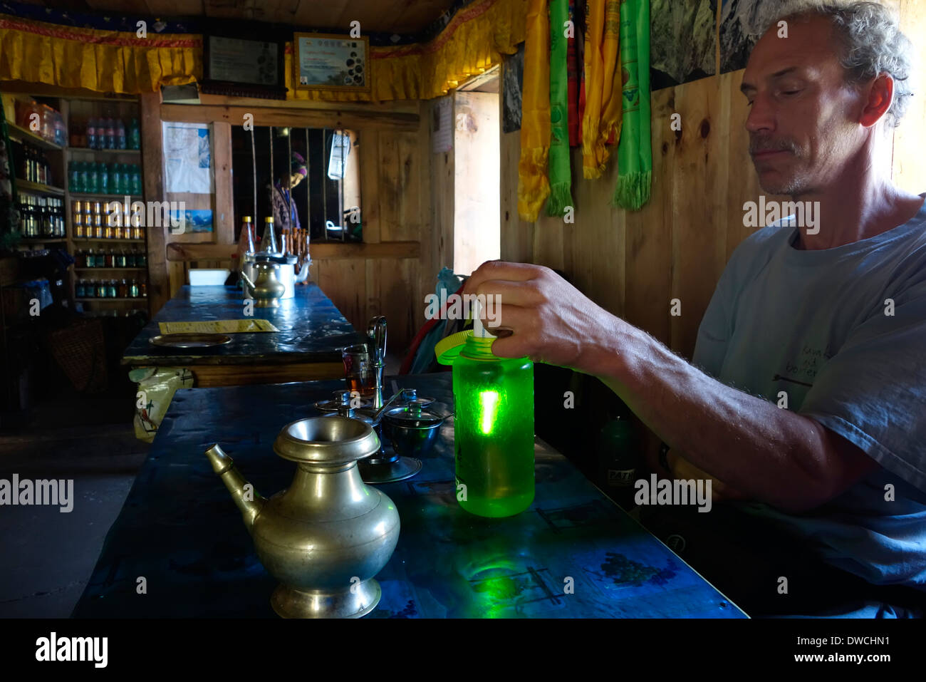 Trekker sterilizing water using a Steripen on a trek in the Himalayan range of Nepal. Stock Photo